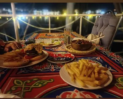 a table topped with plates of food and french fries at Moon Boat in Luxor