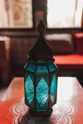 a green glass lantern sitting on a table at Villa Barba Luxor in Luxor