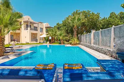 a swimming pool with two lounge chairs in front of a house at Beautiful apartment with terrace to the pool in Hurghada