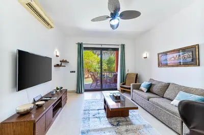 a living room with a couch and a flat screen tv at Beautiful apartment with terrace to the pool in Hurghada