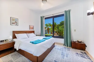 a bedroom with a bed and a large window at Beautiful apartment with terrace to the pool in Hurghada