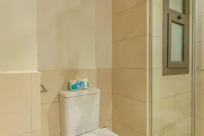 a bathroom with a toilet and a glass shower at Sunny 1BR Retreat Newest Project Shedwan El Gouna Lagoon & Pool in Hurghada