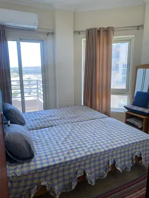 a bedroom with a bed with a checkered blanket at Princess resort 307 in Hurghada