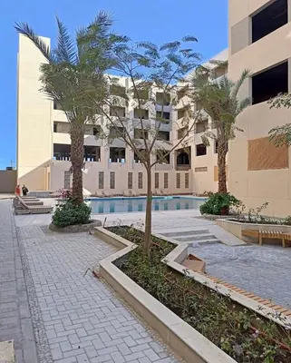 a courtyard with trees and a building with a pool at Princess resort 307 in Hurghada