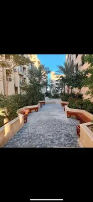 a row of benches on a sidewalk with buildings at Princess resort 307 in Hurghada