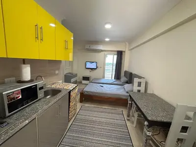 a kitchen with yellow cabinets and a bed in a room at Princess resort 307 in Hurghada