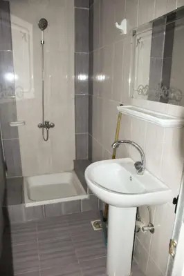 a bathroom with a sink and a shower with a tub at Pauline Guest House in Luxor