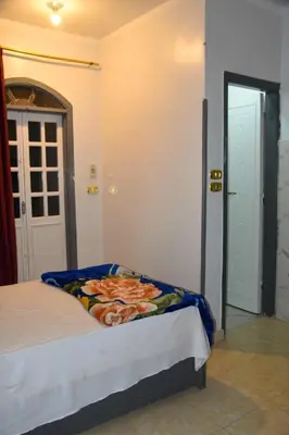 a bedroom with a bed in a room with an open door at Pauline Guest House in Luxor