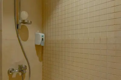 a bathroom with a shower with a shower head at Stylish Gouna Escape 2BR Mangroovy Beach Pool Access in Hurghada