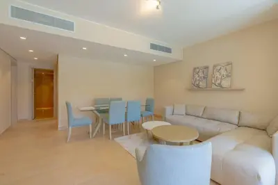 a living room with a couch and a table and chairs at Stylish Gouna Escape 2BR Mangroovy Beach Pool Access in Hurghada