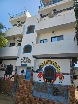 a white building with a painting on it at Basmatic2 Nubian Guest House in Aswan