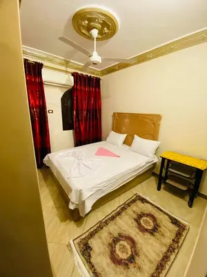 a small bedroom with a bed and a rug at Basmatic2 Nubian Guest House in Aswan