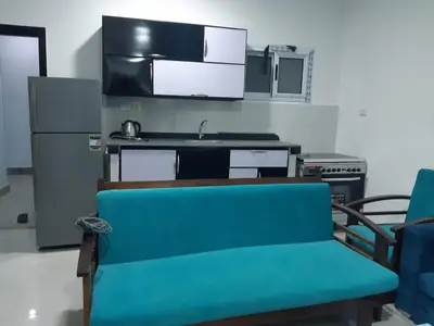 a kitchen with a blue couch and a refrigerator at الغردقة الدهار القيادات in Hurghada