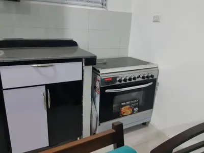 a kitchen with a stove top oven next to a table at الغردقة الدهار القيادات in Hurghada