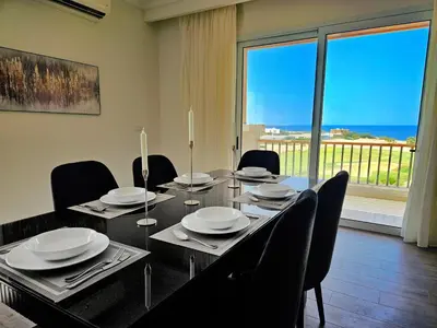 a dining room with a table and chairs and a large window at Soma Bay - Luxury 3 Bedroom Penthouse - Panoramic Sea View, Free Pool and Beach Access in Hurghada