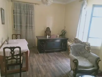 a living room with a table and a chair at Pito home in Luxor
