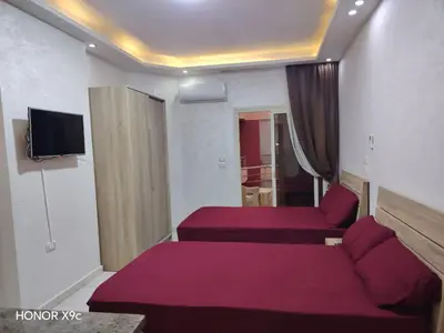 a hotel room with two beds and a tv at Casablanca Beach hurgada كازابلانكا بيتش الغردقه in Hurghada
