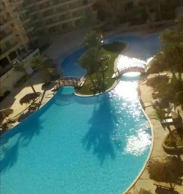 an overhead view of a large blue swimming pool at بالما ريزورت in Hurghada