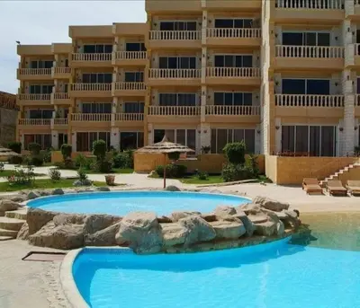 a large building with a swimming pool in front of a building at بالما ريزورت in Hurghada