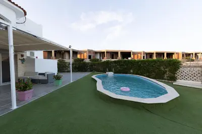 a backyard with a swimming pool on a green lawn at Aden Beach - Sea View room with beach access in Villa in Hurghada
