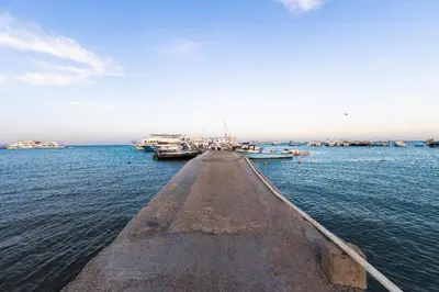 a long dock with boats in the water at Aden Beach - Sea View room with beach access in Villa in Hurghada
