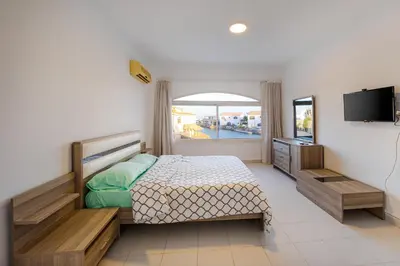 a bedroom with a bed and a television in it at Aden Beach - Sea View room with beach access in Villa in Hurghada