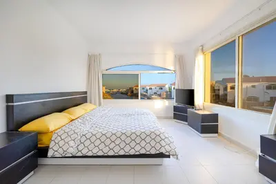 a bedroom with a bed and a large window at Aden Beach - Sea View room with beach access in Villa in Hurghada