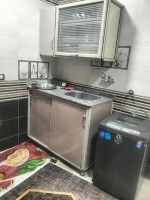 a small kitchen with a sink and a dishwasher at Aswan Key Cozy in Nag` el-Ramla
