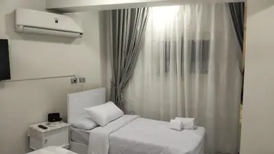 a small room with a bed and a window at Aswan Key Cozy in Nag` el-Ramla