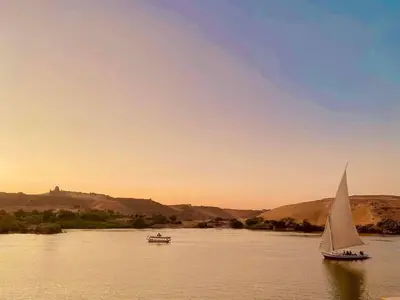two boats on a river with a sail boat at Felucca sailing boat from Aswan to komombo with private bathroom in Aswan