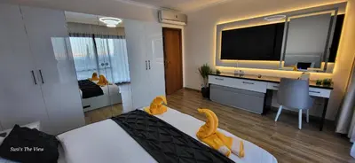 a hotel room with a bed and a desk with a television at Susi`s TheView Luxuriöse Ferienwohnung mit fantastischem Meerblick in Hurghada