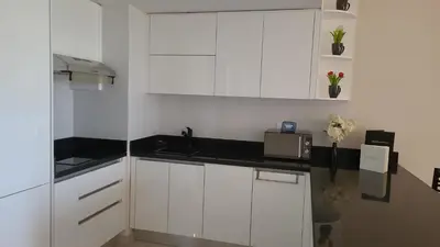a kitchen with white cabinets and a sink and flowers at Susi`s TheView Luxuriöse Ferienwohnung mit fantastischem Meerblick in Hurghada
