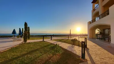 a building with the sun setting in the distance at Susi`s TheView Luxuriöse Ferienwohnung mit fantastischem Meerblick in Hurghada