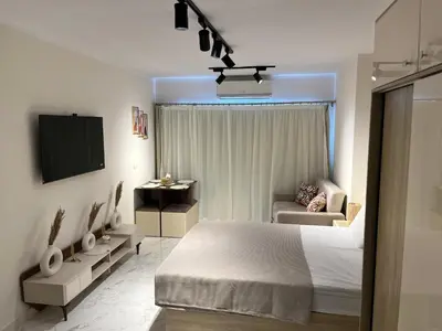 a bedroom with a bed and a tv and a couch at Benashti Hurghada apartment 407 in Hurghada