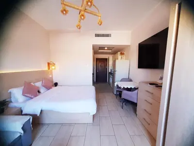 a hotel room with a large bed and a tv at ALDAU Heights Mountain View in Hurghada