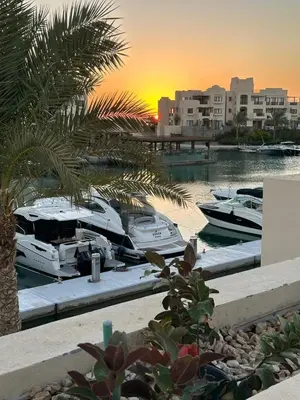 a group of boats docked in a marina at sunset at ElGouna, Elegant 1Bedroom, private patio in Fanadir Marina in Hurghada