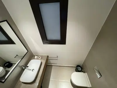 a bathroom with a sink and a toilet and a window at ElGouna, Elegant 1Bedroom, private patio in Fanadir Marina in Hurghada