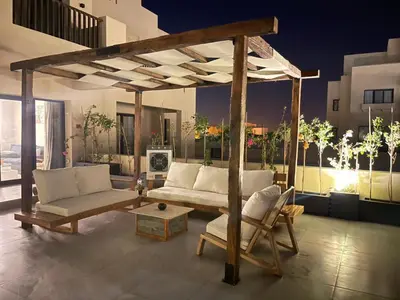 a living room with a couch and a pergola at ElGouna, Elegant 1Bedroom, private patio in Fanadir Marina in Hurghada