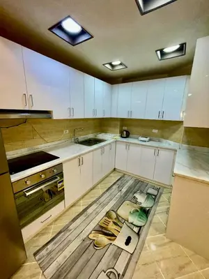 a kitchen with white cabinets and a wooden floor at Sahl Hasheesh, El Andalous by sea and pool view, private beach in Hurghada