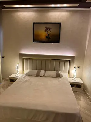 a bedroom with a large bed with two lamps on either side at Sahl Hasheesh, El Andalous by sea and pool view, private beach in Hurghada