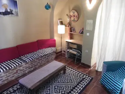 a living room with a couch and a table at maison luxor in Al Aqālitah