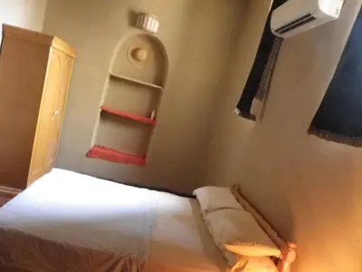 a small bedroom with a bed and a window at maison luxor in Al Aqālitah