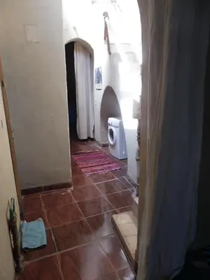 a bathroom with a toilet and a tile floor at maison luxor in Al Aqālitah