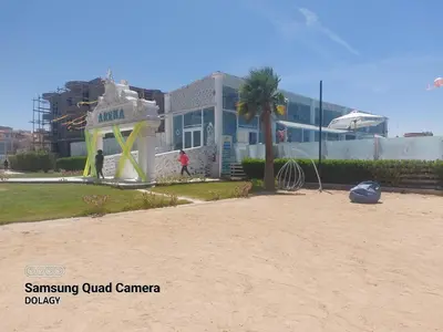 a building on the beach with a palm tree at Selena bay resort in Hurghada