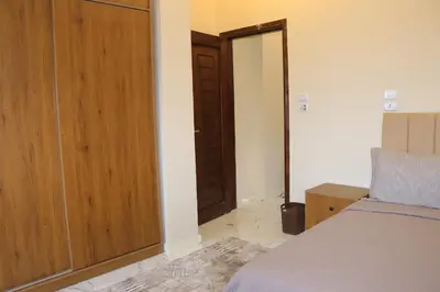 a bedroom with a bed and a wooden door at Hossam Apartment Marina Area Hurghada in Hurghada