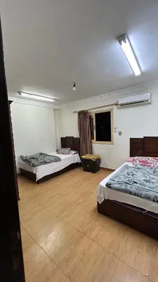a room with two beds and a wooden floor at Super Elite apartment Nile View F6 in Naj‘ al ‘Amrāb