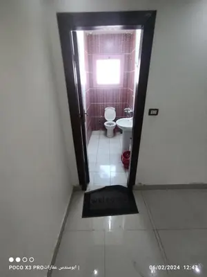 a bathroom with a toilet and a door with a window at Super Elite apartment Nile View F6 in Naj‘ al ‘Amrāb