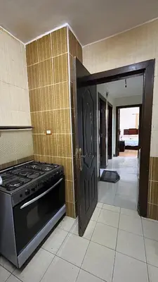 a kitchen with a stove and a black door at Super Elite apartment Nile View F6 in Naj‘ al ‘Amrāb