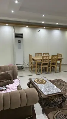 a living room with a couch and a table and chairs at Super Elite apartment Nile View F6 in Naj‘ al ‘Amrāb