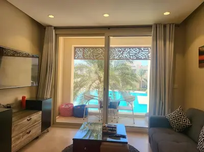 a living room with a couch and a view of a pool at Mangroovy Serinity 2br pool view in Hurghada